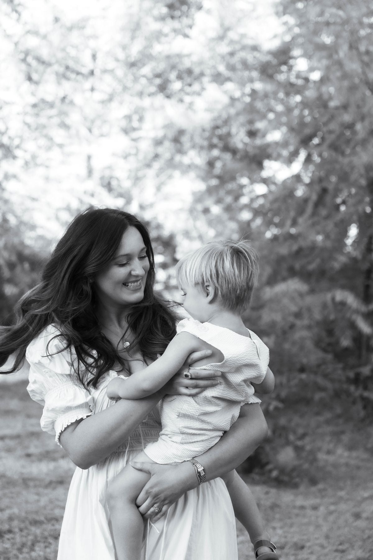 Taylor holding her son outdoors, both smiling